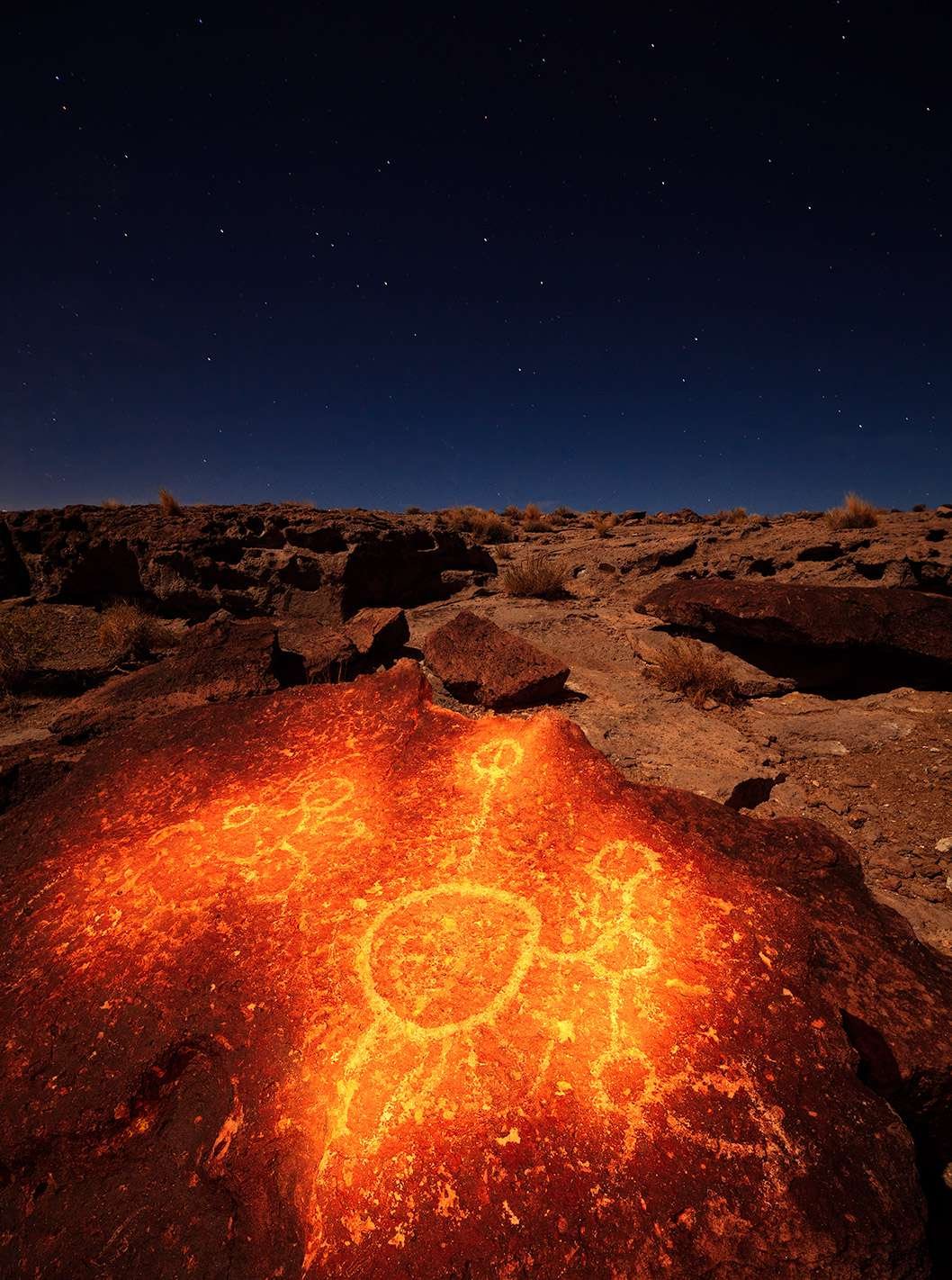 Ancient native American petroglyphs under the night sky at Vulcanic Tablelands.