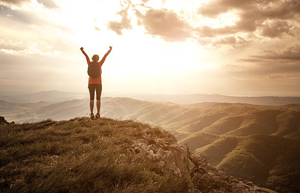 woman-greeting-the-sun-on-the-top-of-the-hill-picture-id625758234.jpg