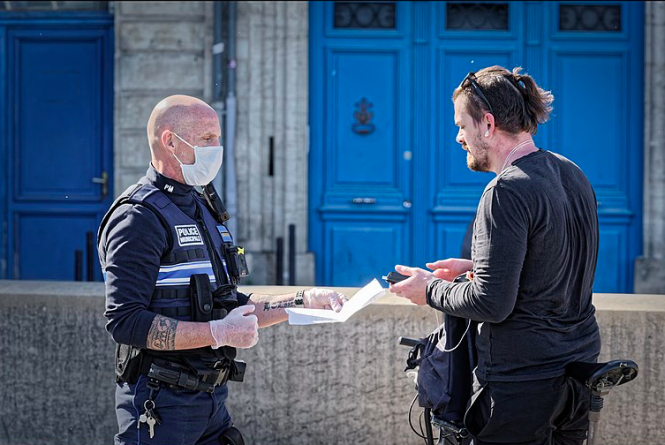 A-policeman-checks-an-attestation-form-in-Bordeaux.png