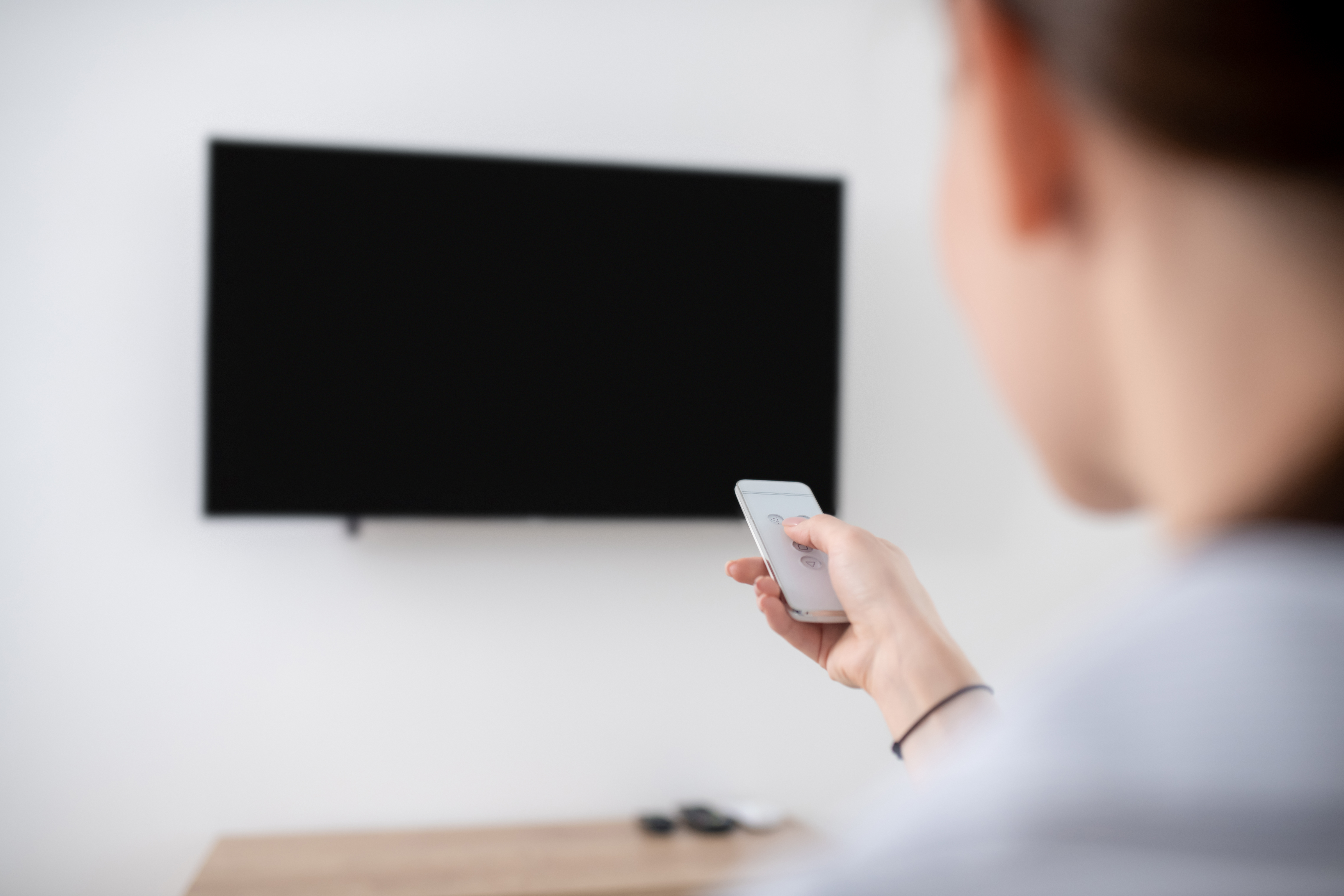 female-turning-on-the-wall-mounted-plasma-tv.jpg