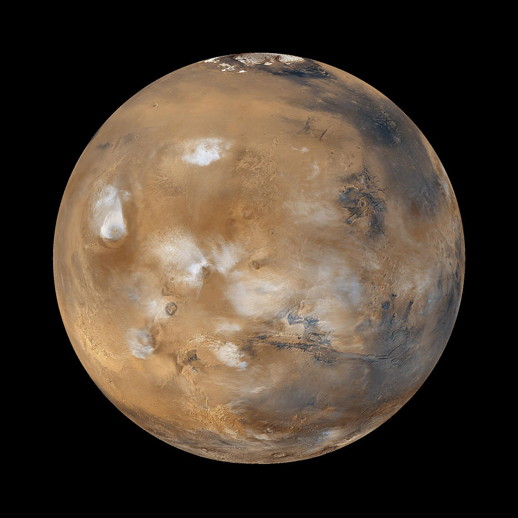 1024px-Water_ice_clouds_hanging_above_Tharsis_PIA02653_black_background.jpg