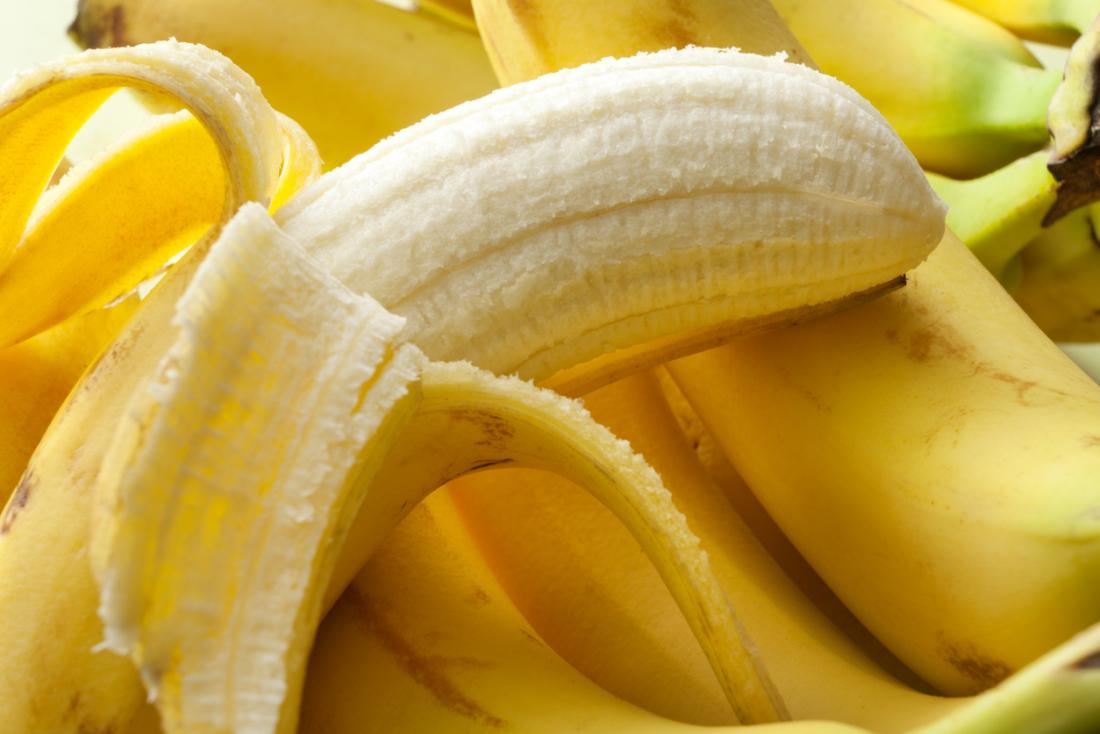 half-peeled-banana-on-top-of-bunch-of-bananas.jpg