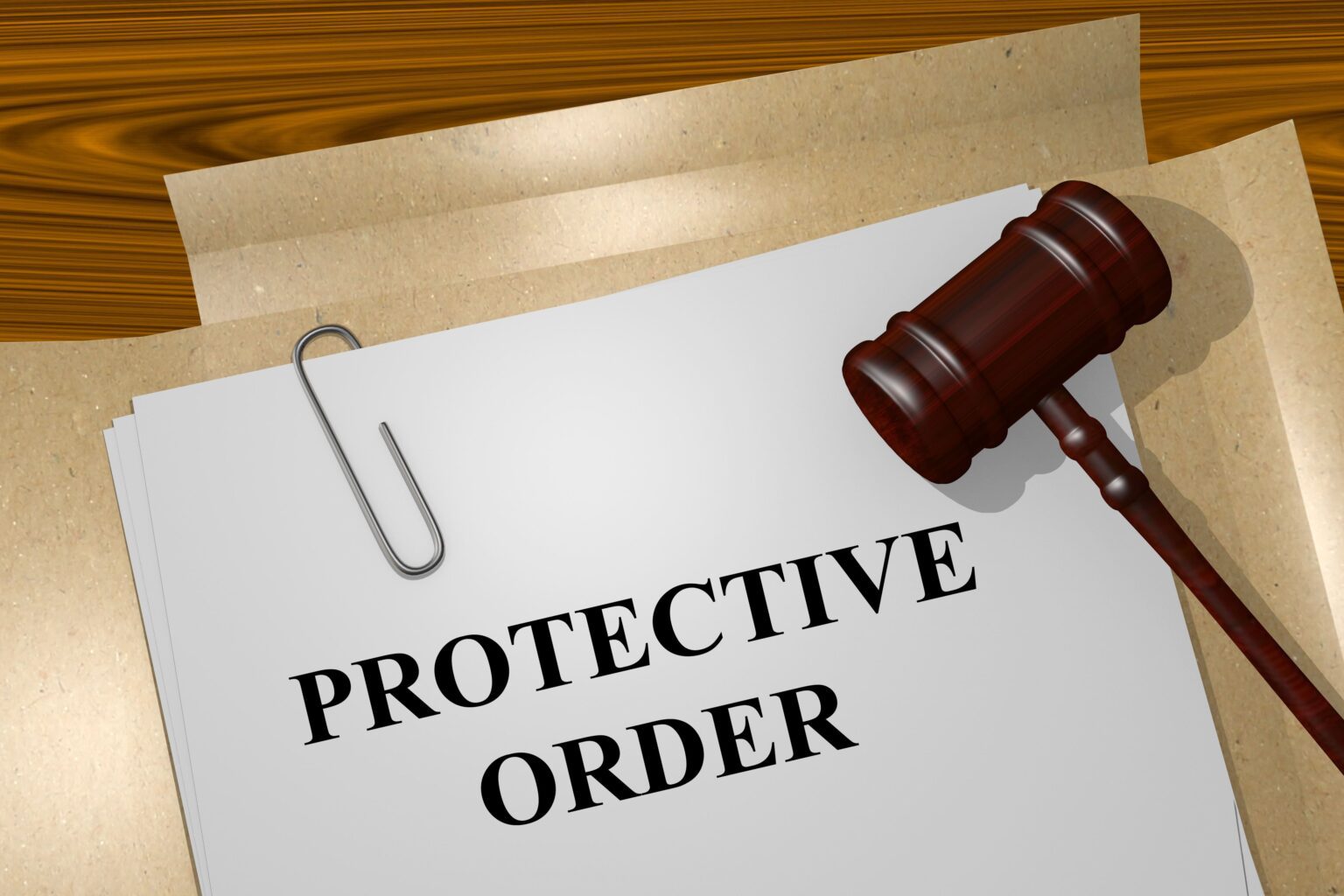 A wooden judge’s gavel rests on paperwork labeled “PROTECTIVE ORDER,” with a large paper clip on the page.