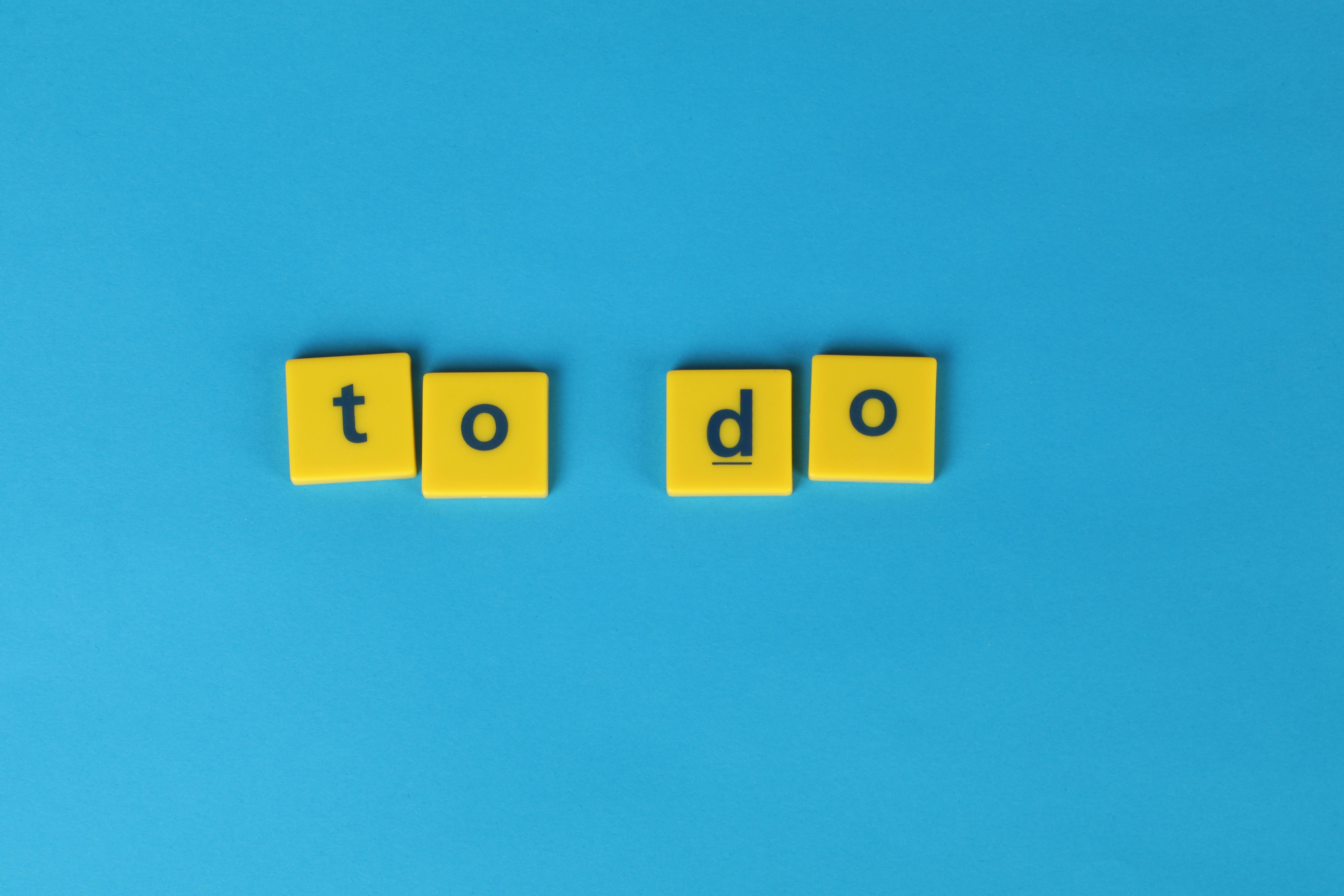 “Yellow letter blocks spelling ‘to do’ on a blue background.”