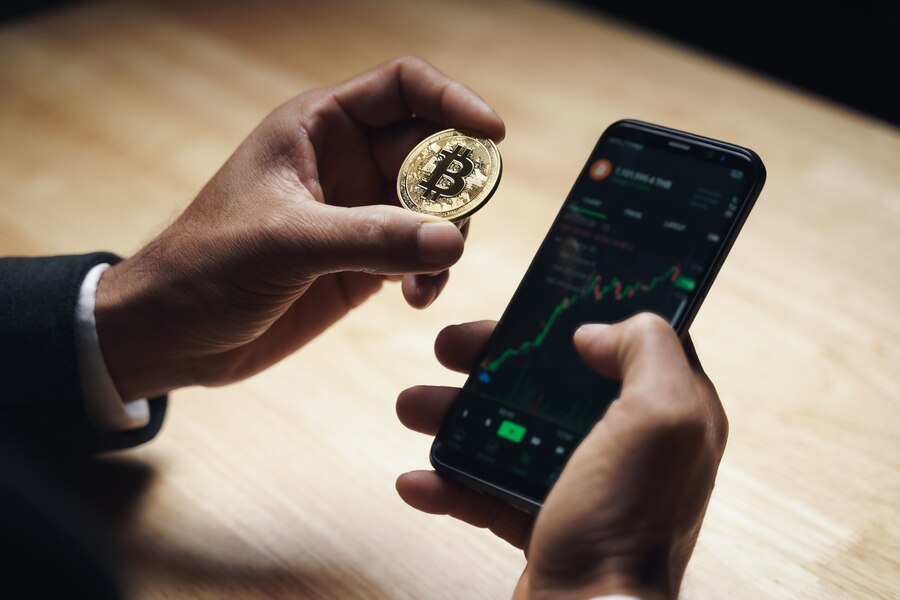 businessman-black-suit-holding-golden-bitcoin-using-smartphone-with-bitcoin-trading-chart-screen-trading-cryptocurrency-alternative-finance-investment-concept_59017-629.jpg