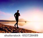 stockphotomanrunningatseasidetwilighttimerunnerathleterunningatseasidesportsmanfitness653728489.jpg