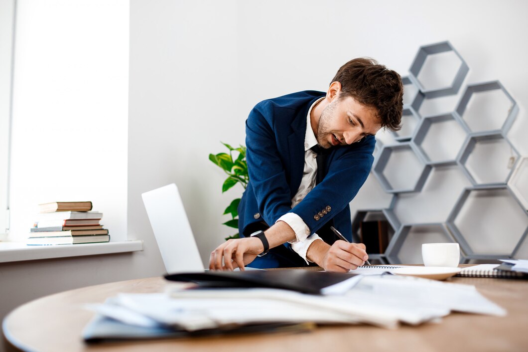 absentminded-young-businessman-speaking-phone-office-background_176420-5270.jpg