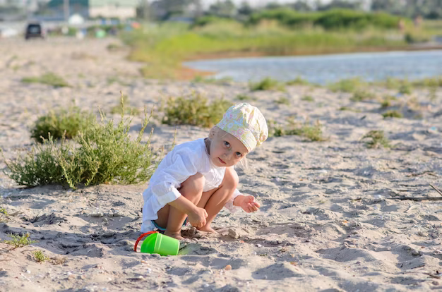 little-girl-playing-sand-near-sea_88340-4719.avif