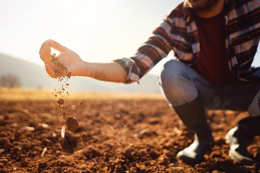 an-unrecognizable-farmer-working-in-the-field-hes-analyzing-his-land.jpg