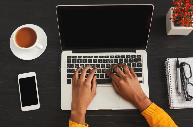 black-female-hands-typing-laptop-keyboard-top-view-african-american-woman-working-office-desktop-smartphone-110465841.jpg
