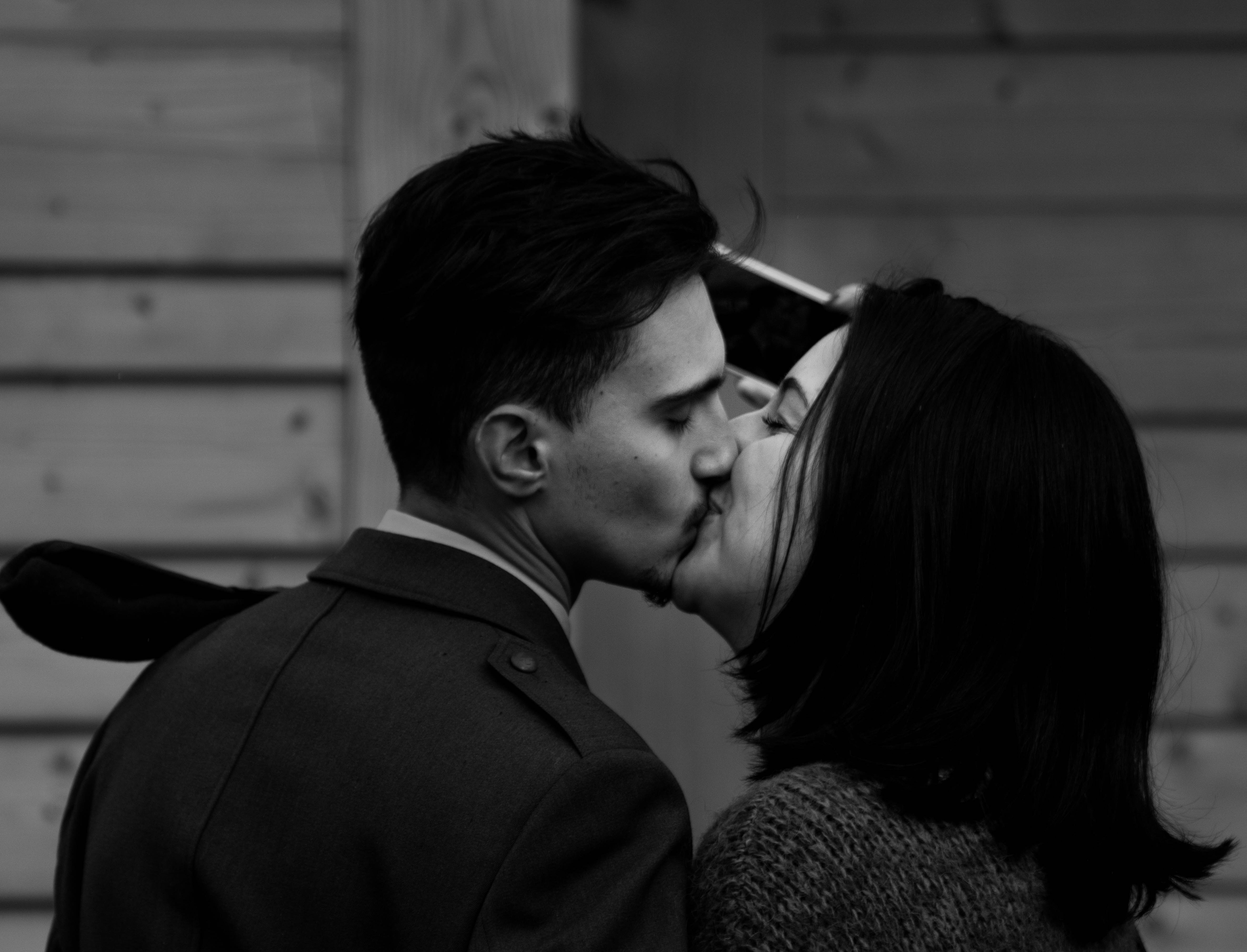 Мужчина целует жену. Поцелуй. Парень и девушка целуются. Поцелуй фото картинки. Поцелуй с перьями.