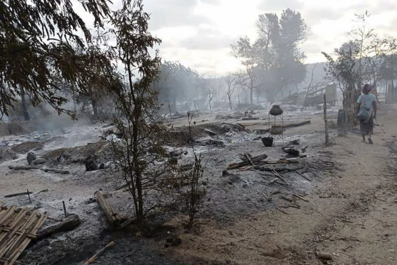 resident-walks-past-burning-houses.webp