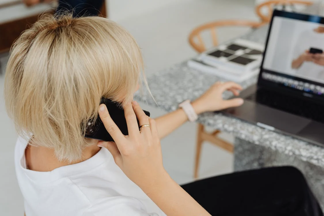 freelancer sitting at their workspace with a phone and laptop