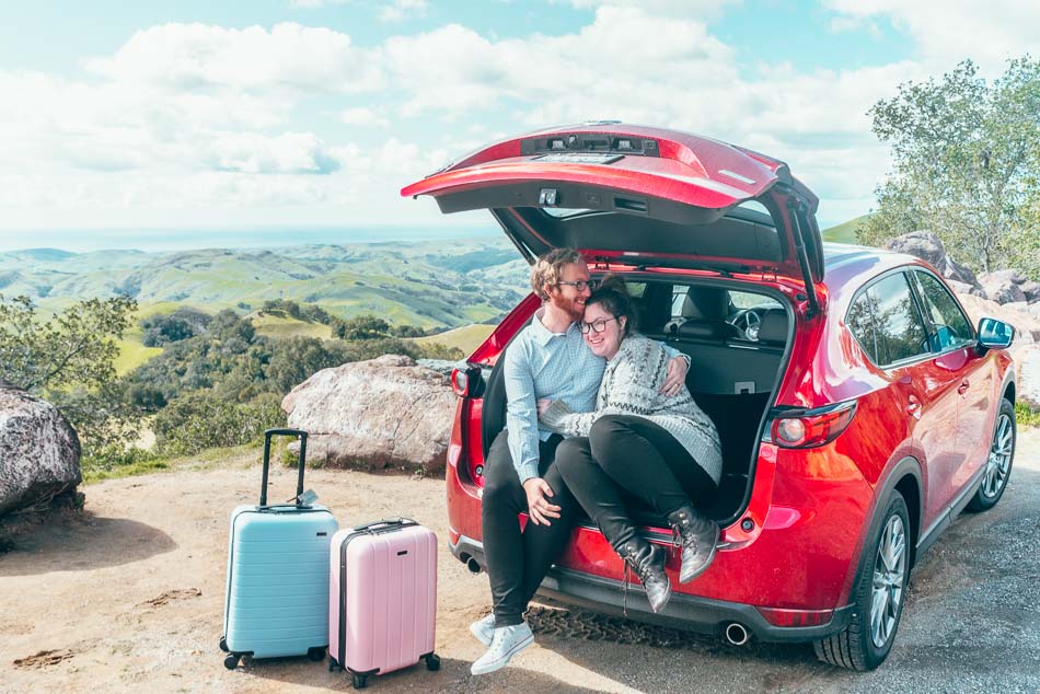 Couple-in-Red-Car-with-Suitcases-California-Highway-One-Road-Trip.jpg